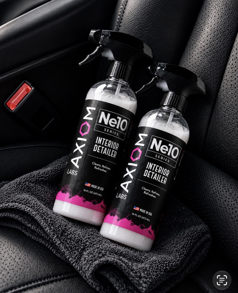 Two Axiom Labs Ne10 Interior Detailer bottles on a towel in a car interior